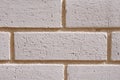 Wall of white bricks with yellow fugue