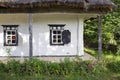 Wall from the whitewashed clay of an old house with rounded windows in rectangular black frames with shutters Royalty Free Stock Photo