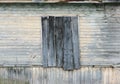 the wall of the wooden house with the old green paint and boarded up window. Royalty Free Stock Photo