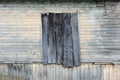 the wall of the wooden house with the old green paint and boarded up window. Royalty Free Stock Photo