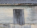 the wall of the wooden house with the old green paint and boarded up window. Royalty Free Stock Photo