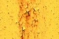 Wall with yellow peeling paint with cracks and rust. Speckles on a painted surface. Aging weathered texture Royalty Free Stock Photo