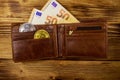 Wallet with fifty euro bills and bitcoins on wooden background Royalty Free Stock Photo