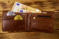 Wallet with fifty euro bills and bitcoins on wooden background Royalty Free Stock Photo