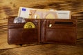 Wallet with fifty euro bills and bitcoins on wooden background Royalty Free Stock Photo