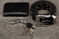 Wallet, keys and leather belt on black background, men accessories concept