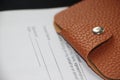 Wallet made of brown natural leather on Agreement or contract. Business concept