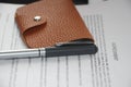 Wallet made of brown natural leather put on Agreement or contract. Business concept