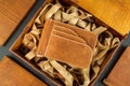 Wallet made of genuine leather on the table in the process of packing a gift on a brown background