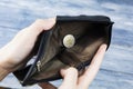 A wallet with money and coins in his hands on a dark background, top view. A euro coin in the palm of your hand. First Royalty Free Stock Photo