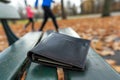 wallet on park bench with jogger in background Royalty Free Stock Photo