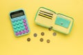 Wallet, scattered coins and calculator on a yellow background. The concept of budget management Royalty Free Stock Photo