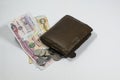 A wallet and UAE dirhams and coins with white background