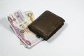 A wallet and UAE dirhams and coins with white background