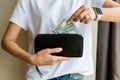 Wallet with US dollars in the woman hands, cash pay or shopping concept. Girl get out the money from the black leather purse, hand Royalty Free Stock Photo