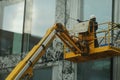 A man washing windows and facade of a building with a mop.