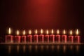 red candles alight on red background, seasonal, holidays, christmas