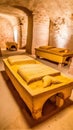 Heavy coffins lie on sand floor in an very small old dusty cemetery crypt in a cave