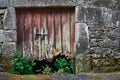 Walls of facade of old abandoned stone house covered in mold with broken wooden door in small medieval village called Bainte, Royalty Free Stock Photo