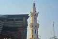 the walls of a house and a TV antenna, with the white minaret of a mosque in focus