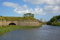 Walls and moat of the citadel of Calais, with apartment buildings in the background