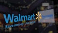 Walmart logo on the glass against blurred business center. Editorial 3D rendering