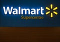 Walmart superstore exterior facade brand logo signage at night. Walmart is an American multinational retail corporation