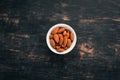 Walnut almonds. On a black wooden background.