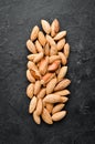 Walnut almonds in the shell. Nuts on a black stone background. Top view.