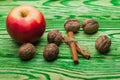 Walnut apple and cinnamon on green wood Royalty Free Stock Photo