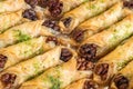 Walnut baklava rolls on an aluminium tray. Turkish layered pastry dessert filled with walnuts