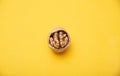 Walnut with broken shells on a yellow background, close-up. Walnut resembling a human brain