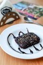 Walnut brownie bite served in a white plate with chocolate sauce garnishing Royalty Free Stock Photo