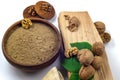 Walnut flour in ceramic bowl, walnuts with green leaves, cookies and firewood