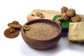 Walnut flour in ceramic bowl, walnuts with green leaves, cookies and firewood