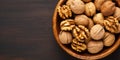 Walnut kernel halves in a wooden bowl Close up from above on colored background 3