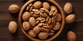 Walnut kernel halves in a wooden bowl Close up from above on colored background 2