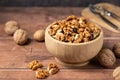 Walnut kernel in a wooden bowl. Shelled, dried seeds of walnuts in wooden bowl. Copy space.