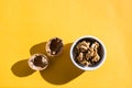 Walnut kernels in a bowl and walnut shells on a yellow table Royalty Free Stock Photo