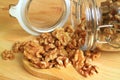 Walnut Kernels Scattered from Glass Jar on a Wooden Spoon on Wooden Table