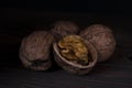 Walnut kernels, and walnuts on a dark background.