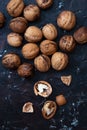 Walnut kernels and whole walnuts on rustic background. top view
