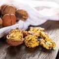 Walnut kernels and whole walnuts on rustic old wooden table. Fresh walnuts on wooden board Royalty Free Stock Photo