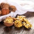 Walnut kernels and whole walnuts on rustic old wooden table. Fresh walnuts on wooden board Royalty Free Stock Photo