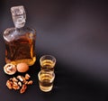 Walnut liqueur in a bottle and two glass goblets on a black background Royalty Free Stock Photo