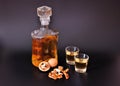Walnut liqueur, strong homemade alcohol in two glasses and a bottle on a black background Royalty Free Stock Photo