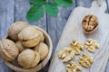 Walnut nut in wooden bowl on wood table with green leaf background, copy space Royalty Free Stock Photo