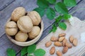 Walnut nut in wooden bowl on wood table with green leaf background, copy space Royalty Free Stock Photo