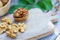 Walnut nut in wooden bowl on wood table with green leaf background, copy space Royalty Free Stock Photo