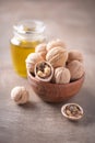 Walnut nuts in wooden bowl and walnut oil in bottle on wood textured background. Copy space. Superfood, vegan, vegetarian food Royalty Free Stock Photo